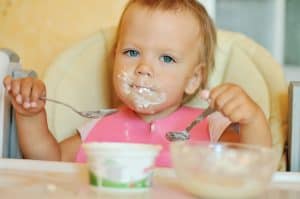Baby Eating with two spoons